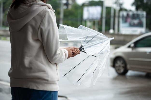 雨の中で傘を持つ若い女性