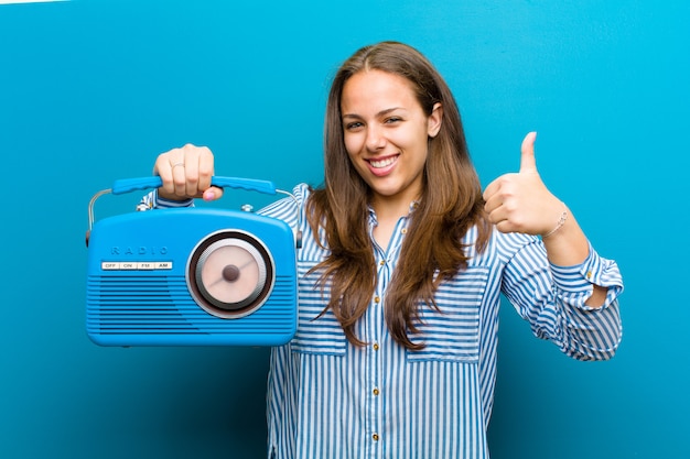 Young woman with a vintage radio against blue background