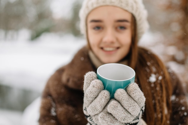 Young woman with warm mug winter portrait