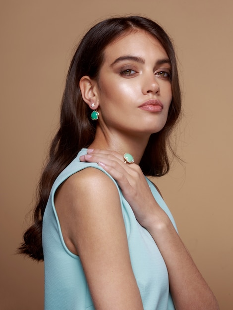 Young woman with wavy hairstyle dressed in blue dress