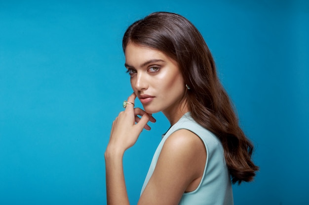 Young woman with wavy hairstyle dressed in blue dress