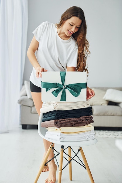 Young woman with white gift box Interior and design of beautiful modern bedroom at daytime