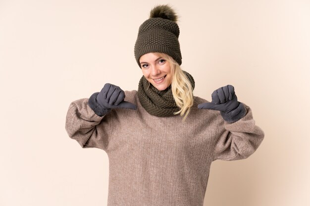 Foto giovane donna con cappello invernale sopra isolato orgoglioso e soddisfatto di sé