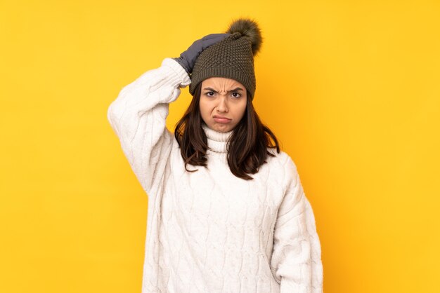 Young woman with winter hat isolated with an expression of frustration and not understanding