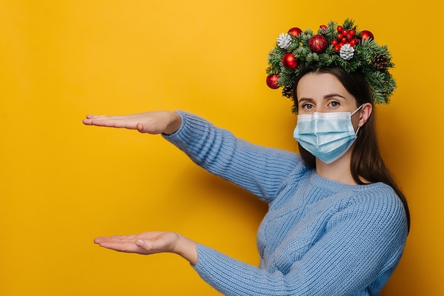 Young woman with wreath around head wearing mask