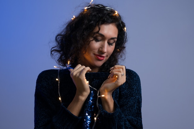 Young woman with xmas glowing lights celebration