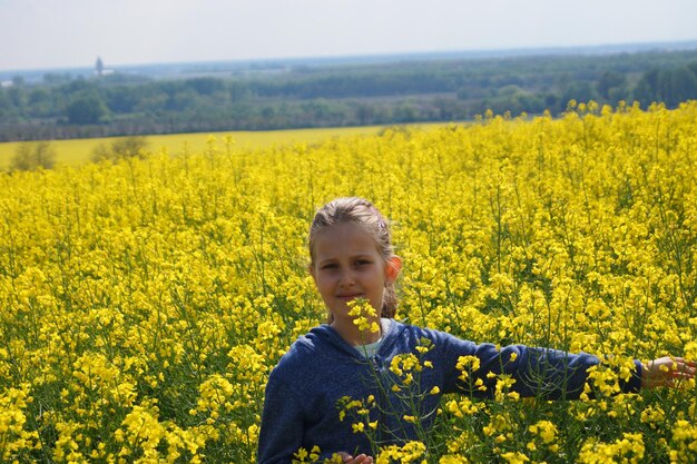 Young woman with yellow flowers in field