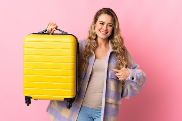 Young woman with yellow travel suitcase