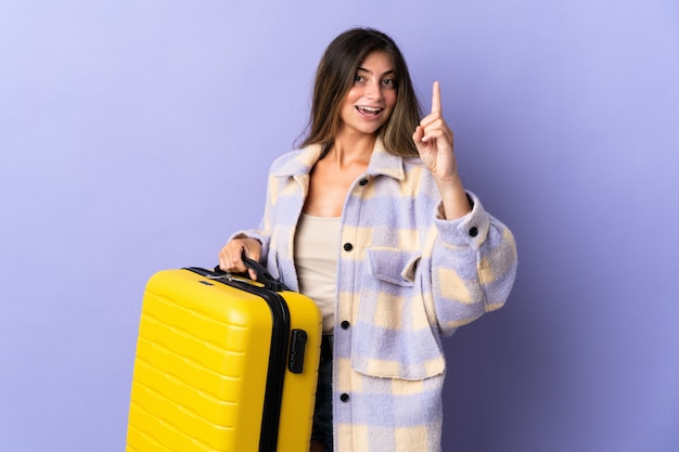 Young woman with yellow travel suitcase