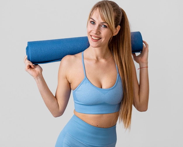 Young woman with yoga mat