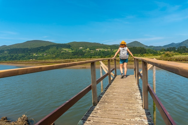 A young woman on the wooden piers of the Urdaibai marshes, a Bizkaia biosphere reserve next to Mundaka. Basque Country