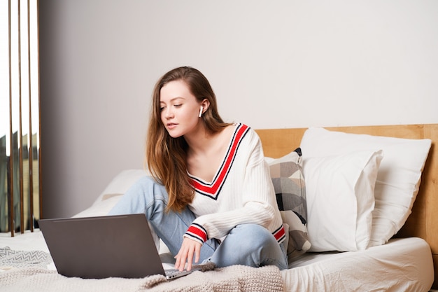 Young woman working in bed