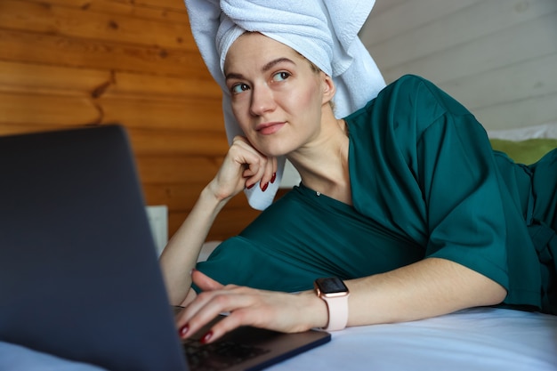 샤워 후 컴퓨터에서 일하는 젊은 여자