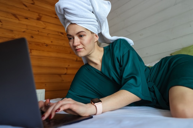 Young woman working at the computer after a shower