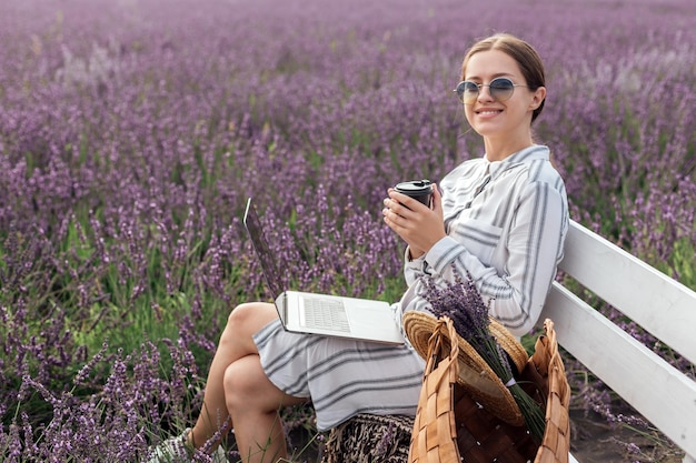 Young woman working at the computer in lavender field