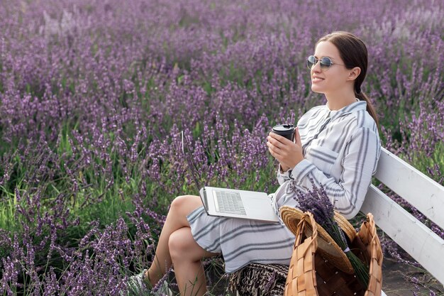 Young woman working at the computer in lavender field