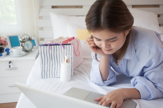 Foto una giovane donna che lavora da casa con sul computer portatile.