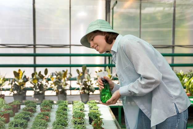 Photo young woman working in a greenhouse