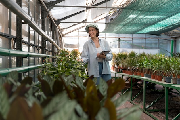 Photo young woman working in a greenhouse
