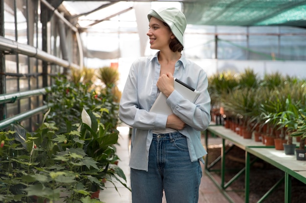 Photo young woman working in a greenhouse