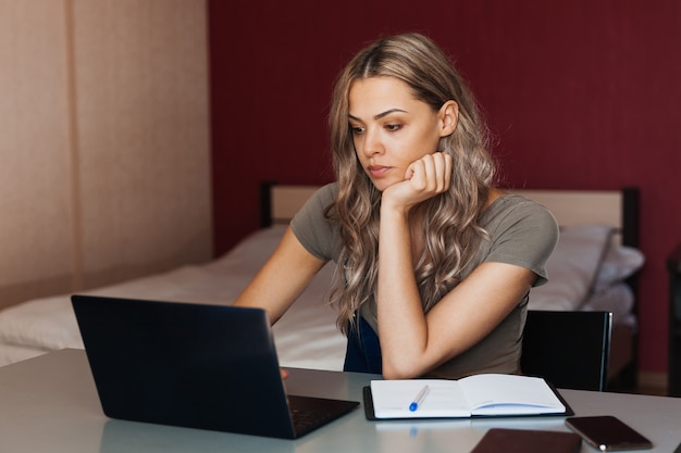 Young woman working at home using laptop