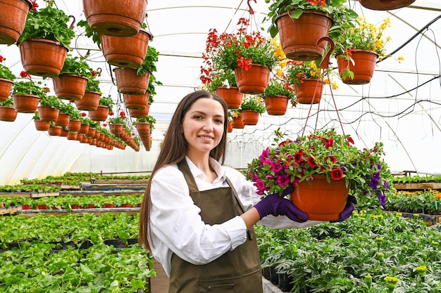 写真 美しい色とりどりの花畑の温室で働く若い女性私の仕事は私の情熱です