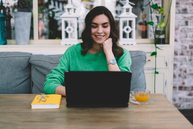 Young woman working on laptop in cafe