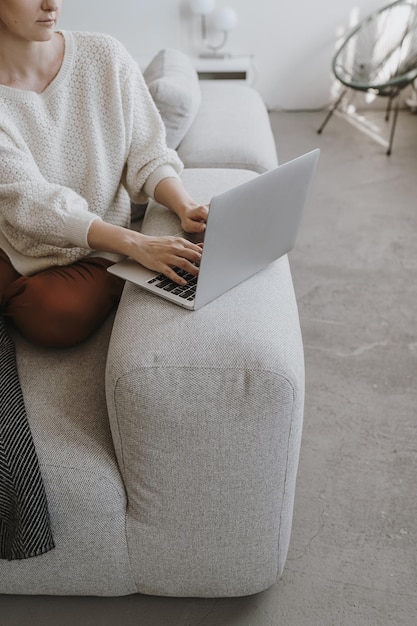 Photo young woman working on laptop computer sitting on comfortable sofa aesthetic work at home freelancer concept elegant girl boss lady boss business composition for blog web social media