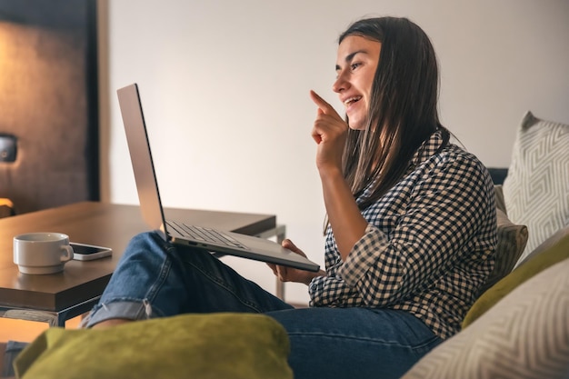 A young woman working on a laptop at home