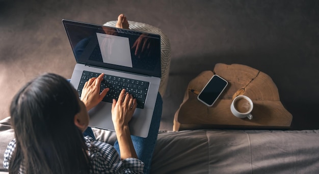 Una giovane donna che lavora su un laptop a casa