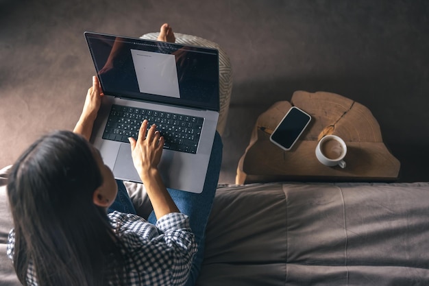 Una giovane donna che lavora su un laptop a casa