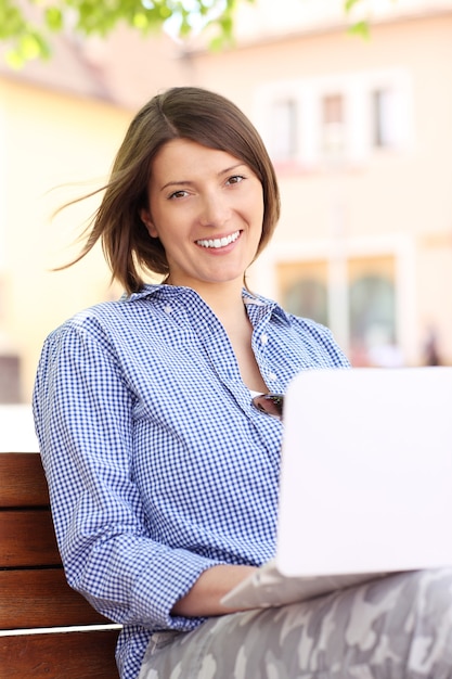 a young woman working on laptop in the park