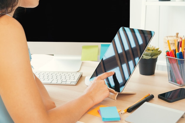 Young woman working in office using computer, sitting at desk