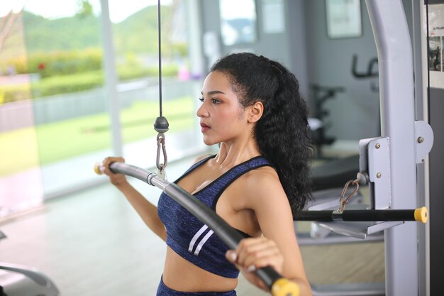 Giovane donna che lavora in palestra utilizzando attrezzature da palestra