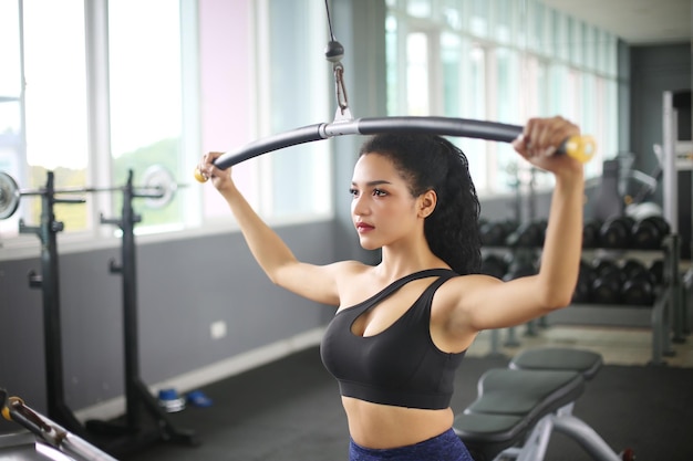 Young woman working out in gym using gym equipment