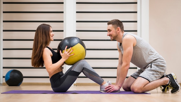 写真 若い女性が彼女のトレーナーとワークアウト