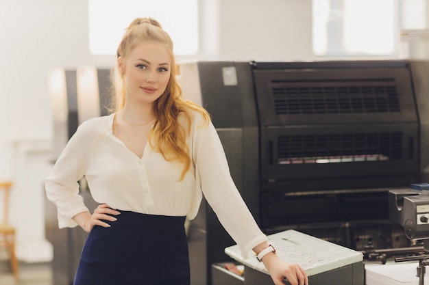 Young woman working in printing factory. Printing Press.