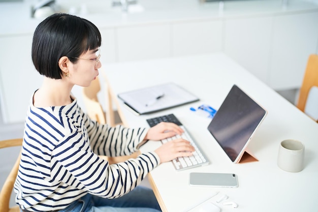 部屋のテーブルで働く若い女性