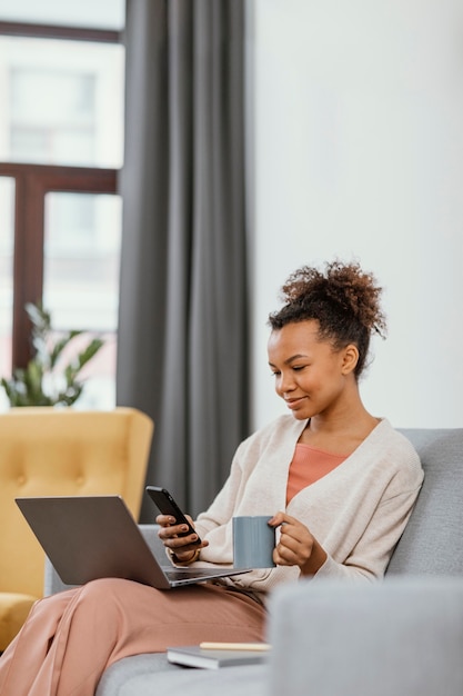 Young woman working while sitting on the sofa