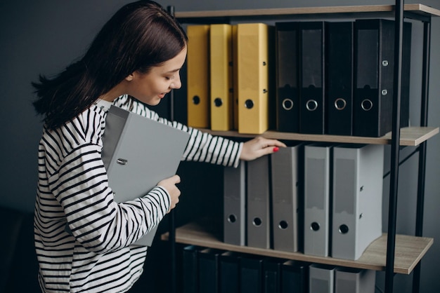 Young woman working with documents and checking archives