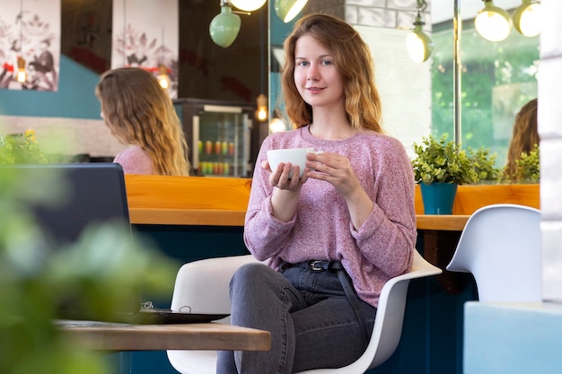 Young woman works for a laptop