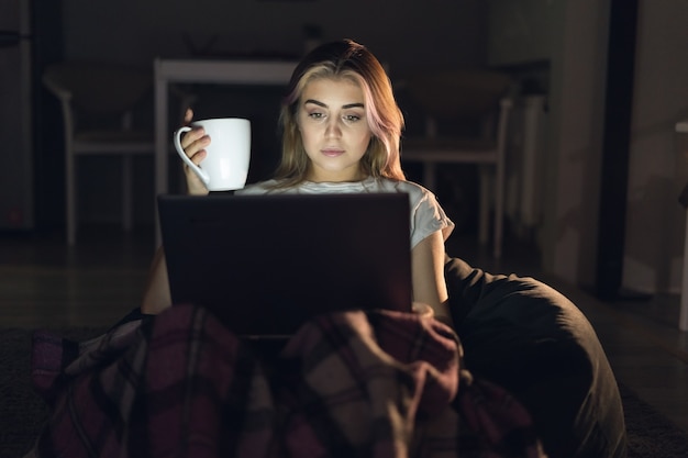 Young woman works online at night