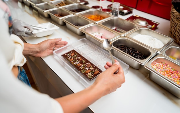 Photo young woman in the workshop during a lesson on making handmade chocolates and sweets