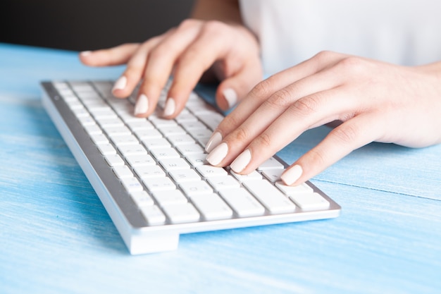 Young woman writes on the keyboard