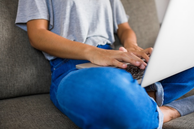 Scrittura della giovane donna sul computer a casa