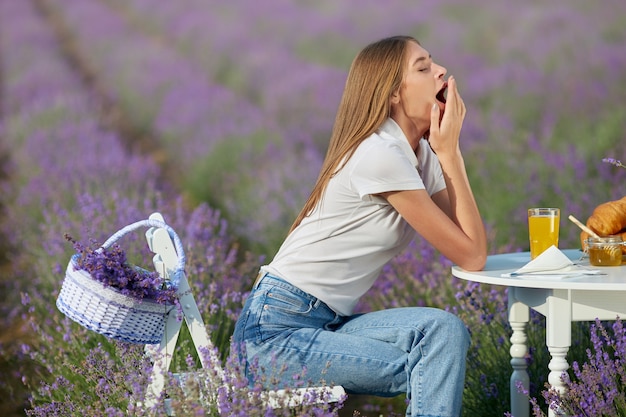 Young woman yawning in lavender field