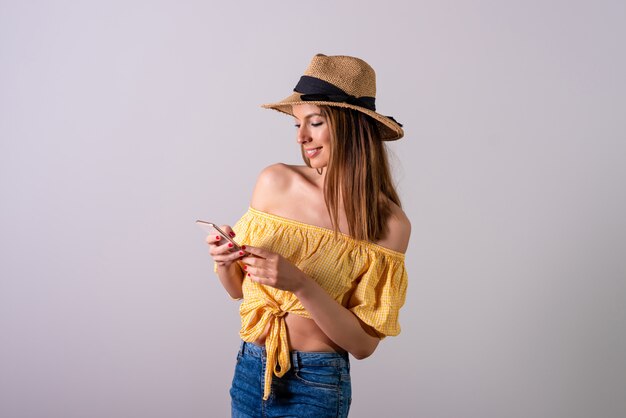 A young woman in a yellow dress using her smartphone