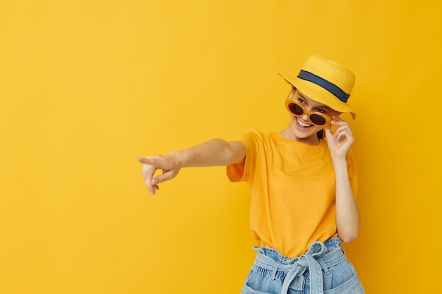 Young woman in a yellow hat Youth style casual wear in sunglasses isolated background