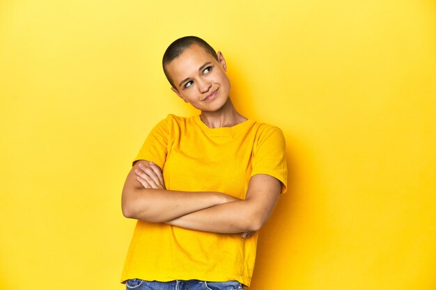 Photo young woman in yellow tee yellow studio backdrop dreaming of achieving goals and purposes