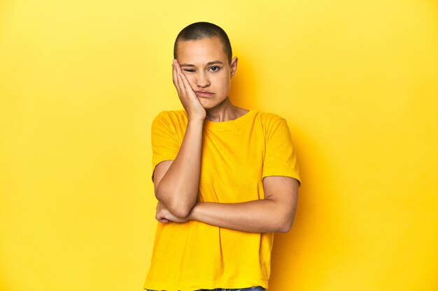 Young woman in yellow tee yellow studio backdrop who is bored fatigued and need a relax day